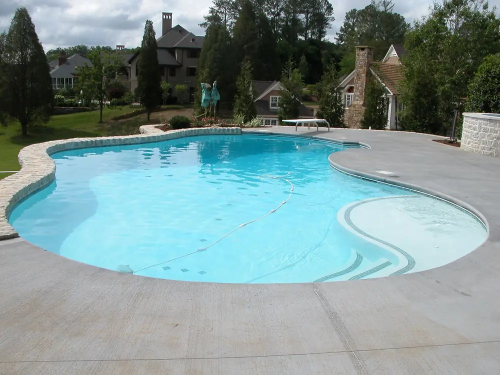 A freeform gunite pool by Sequoyah Pools beside a large Knoxville house.