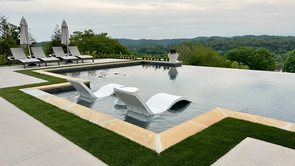 An infinity-edge Sequoyah pool with loungers, the water meeting the horizon.